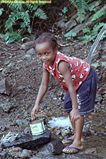 girl washing laundry at pump